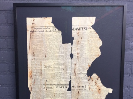 Detail van ingelijste krant achter museumglas